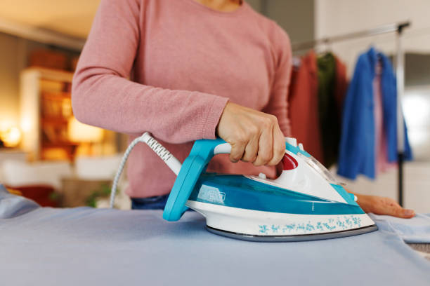 istock Woman ironing clothes on ironing board at home 2194856765