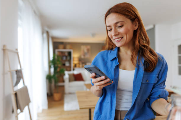 istock Happy woman using mobile phone at home 2194856887