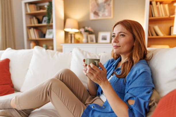 istock Woman relaxing on sofa with cup of coffee or tea 2194857760