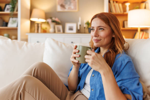 istock Serene woman relaxing on sofa with a cup of coffee or tea 2194857862