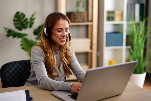 istock Smiling businesswoman working remotely using headset and laptop 2194858256
