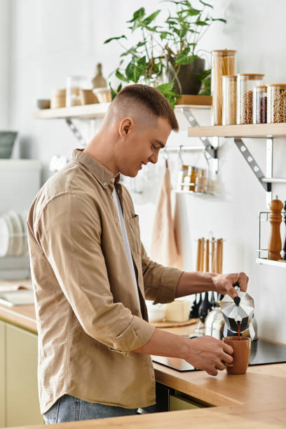 istock Charming young man brewing coffee in his stylish modern apartment kitchen 2194858571