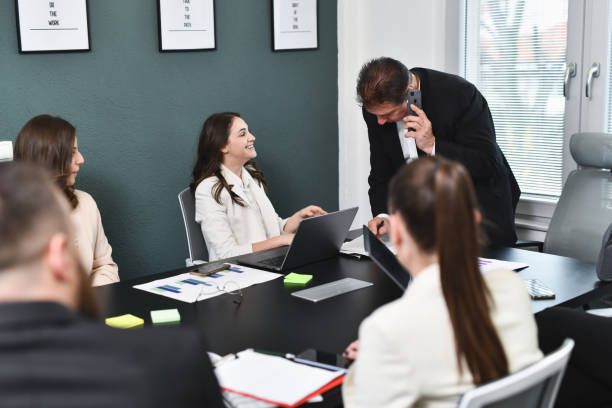 istock Smiling Female Looking at Male CEO Examining Her Report While Talking on Phone 2194860797