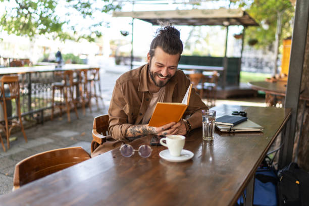 istock Handsome man reading a book at coffee shop 2194863364