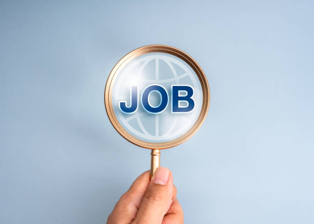 istock Job search online, human resource (HR), hiring, selection, recruitment, career finding concepts. Text JOB with internet earth, global icon in magnifying glass in hand isolated on blue background. 2194864218