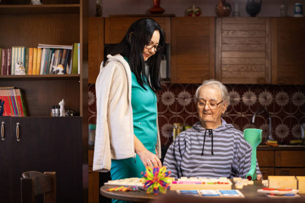 istock Nurse Helping Out Senior Male with Dementia Solve a Memory Puzzle 2194864271