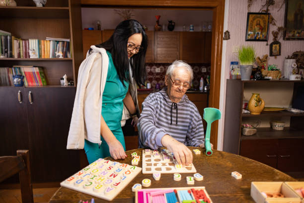istock Nurse Helping Out Senior Male with Dementia Solve a Memory Puzzle 2194864307