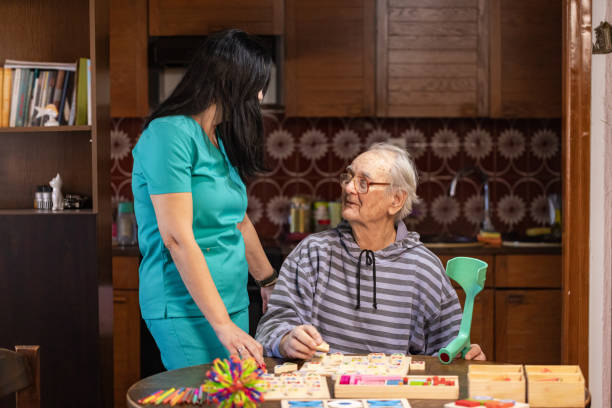 istock Nurse Helping Out Senior Male with Dementia Solve a Memory Puzzle 2194865279