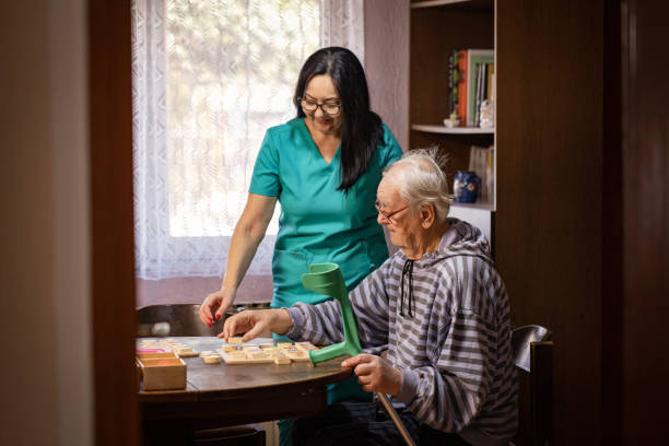 istock Nurse Helping Out Senior Male with Dementia Solve a Memory Puzzle 2194865389