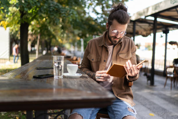 istock Handsome man reading book in outdoors cafe 2194867425