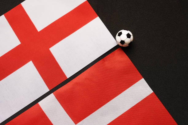 Photorealistic 3d render of a soccer ball textured with English flag isolated on white background. Soccer ball is lit by the upper left corner of the composition and casting shadows on white ground. Horizontal composition with copy space. Clipping path is included.