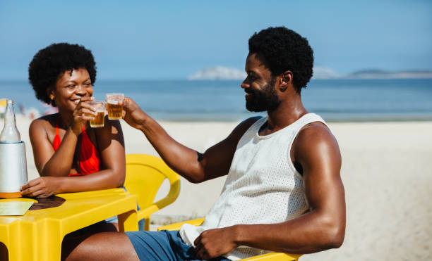 istock Couple clinking drinks at a beachside cafe in Brazil 2194869161