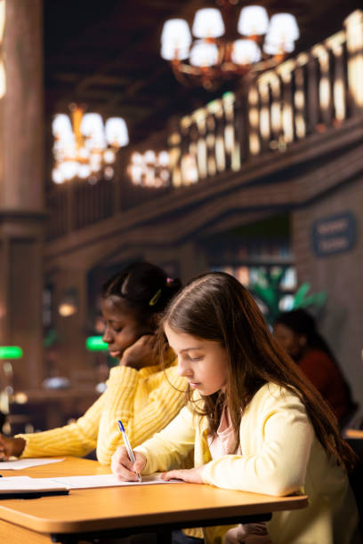 istock Schoolgirls taking notes and completing theoretical exercises in public library 2194870270