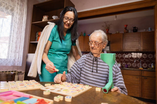 istock Nurse Helping Out Senior Male with Dementia Solve a Memory Puzzle 2194870616