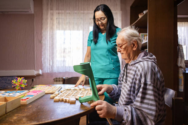 istock Nurse Helping Out Senior Male with Dementia Solve a Memory Puzzle 2194871679