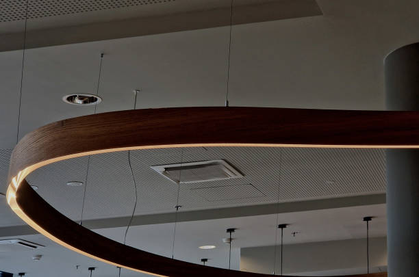 istock the ceiling of the corridor in the plasterboard soffit is equipped with a light ring in a wooden, arc-shaped casing. shines from the joint.  suspended on cables above the dining room table 2194872417