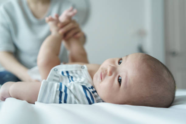 istock Asian Mother changing baby's diaper on a bed in a nursery room 2194873589