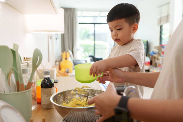 istock Asian woman and a young boy are engaged in a baking activity, using a mixer in the kitchen. 2194873593