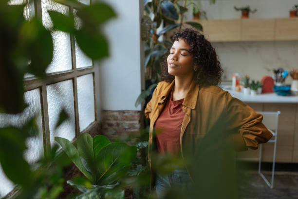 istock Young woman breathing fresh air at home surrounded by plants 2194875708