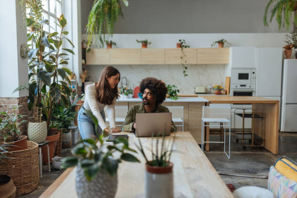 istock Young colleagues collaborating on laptop in plant-filled home office 2194875739
