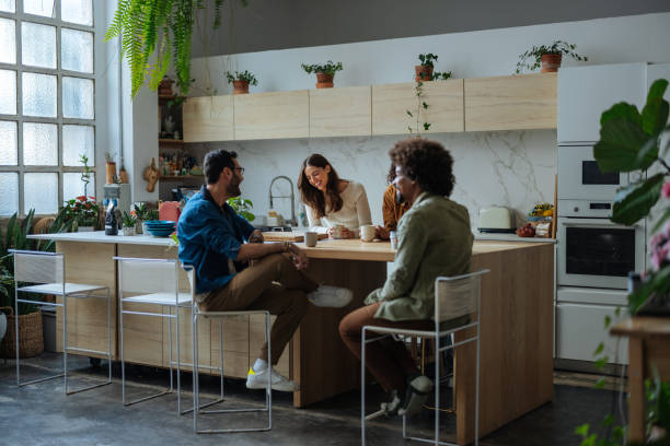 istock Young adults enjoying coffee and conversation in modern kitchen 2194875794