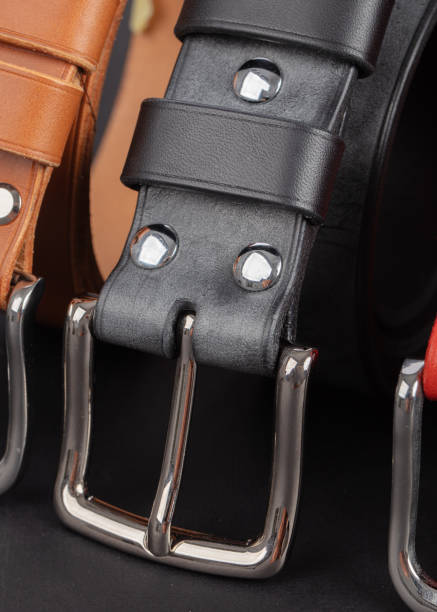 istock Leather belts with metal buckles on a gray background. 2194876721