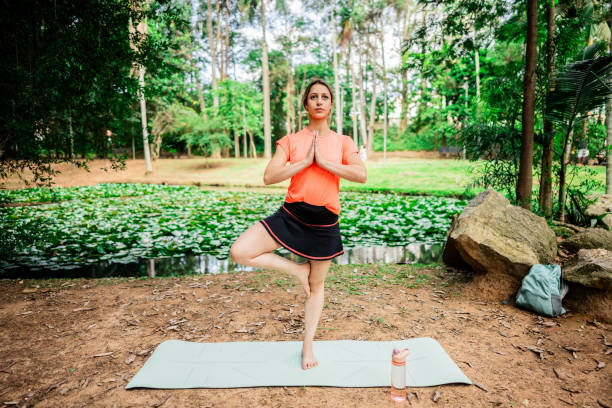 istock Young woman practicing yoga in the park 2194876876