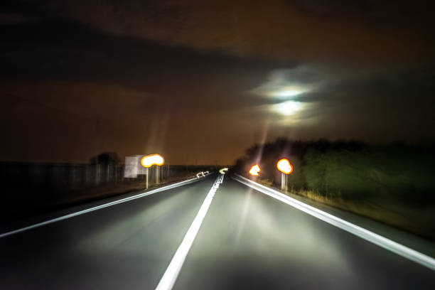 istock Countryside Road at Night with Blurred Motion and Full Moon in View 2194877600