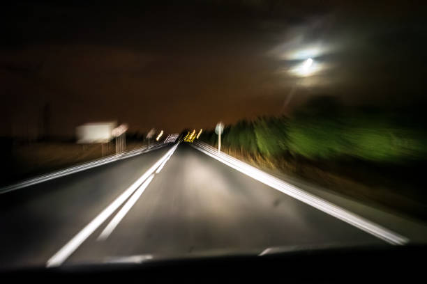 istock Countryside Road at Night with Blurred Motion and Full Moon in View 2194877631