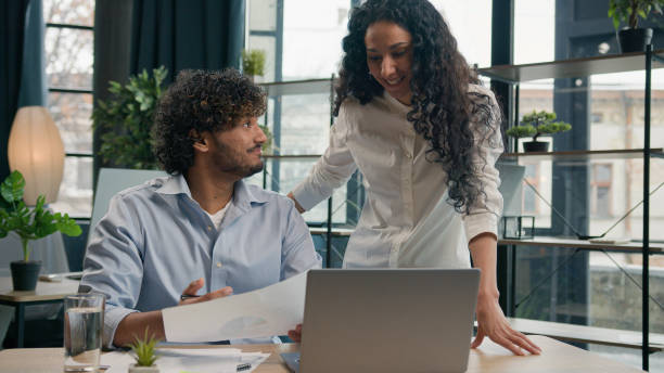 istock Arabian female leader coach help intern explain paperwork and financial data business strategy consult client. Smiling Indian colleague businessman talk with businesswoman corporate teamwork at office 2194877734