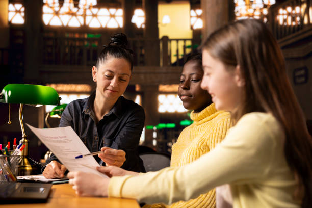 istock Female tutor correcting the homework during private lessons with scholars 2194879101