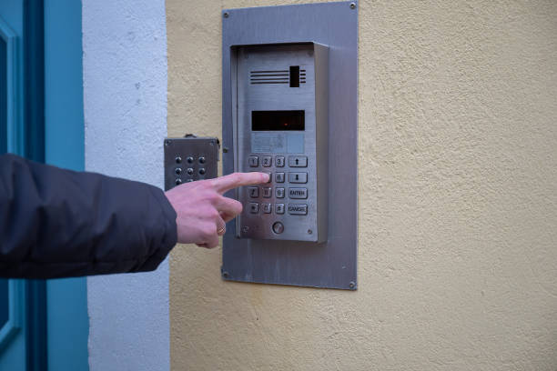 istock Close-up of a hand pressing a button on a metallic door keypad intercom 2194885424