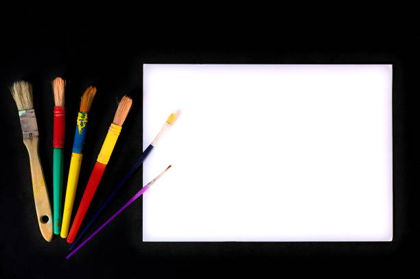 Art supplies featuring colorful paintbrushes and a blank white canvas, ideal for creative projects.