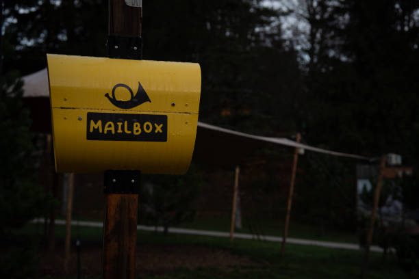 Mashpee, Massachusetts, USA -April 10, 2025-   A blue United States Postal mail collection box by the side of the road on a spring afternoon.