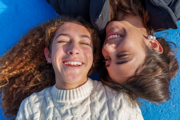 istock Two young women lying on a blue surface are smiling with closed eyes 2194888929