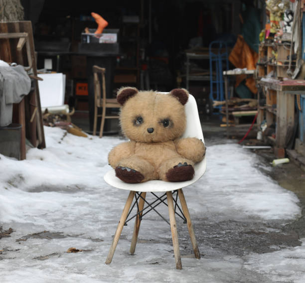 old dirty teddy bear on chair outdoors