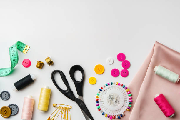 istock Crafting supplies arranged on a table with fabric, thread and buttons during daytime 2194889928