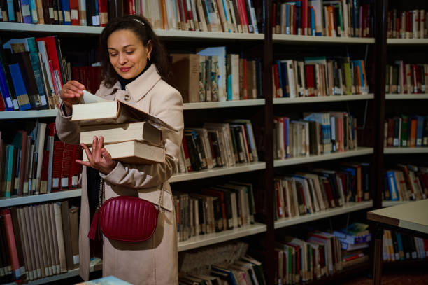 istock Woman browsing books in a library for reading and study purposes 2194890399