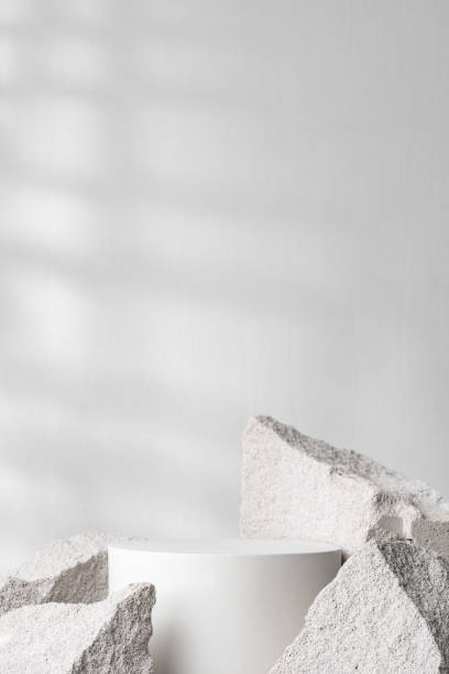 istock A minimalistic display featuring a smooth white cylinder surrounded by rough gray stone fragments 2194890933