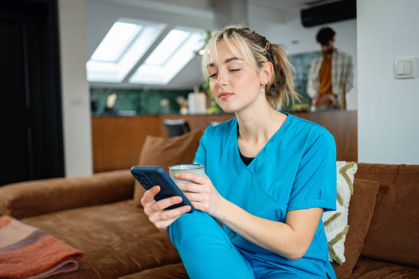 istock Quiet morning for a nurse while drinking coffee and using her mobile phone before a busy shift at work 2194891251