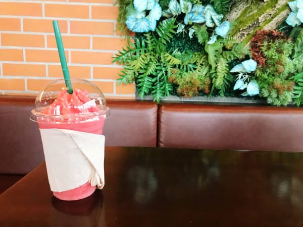 Strawberry smoothie in plastic cup on table in coffee shop