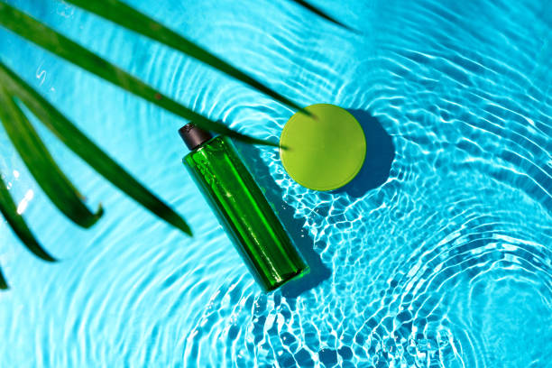 istock Green bottle floating on a clear blue swimming pool during bright daylight 2194892175