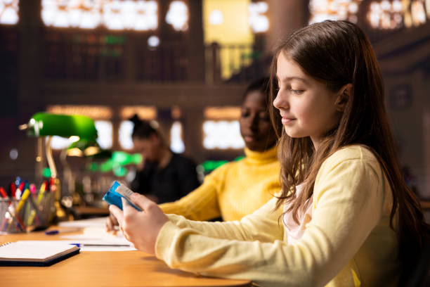 Teenagers immersed in reading literary works from the school library database