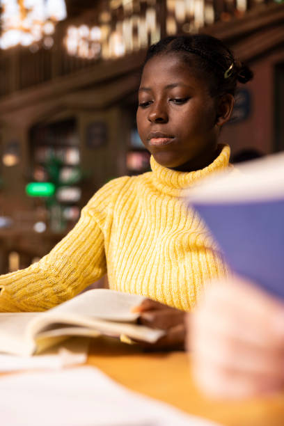 istock African american pupil studying in a public library reading required literature 2194893495