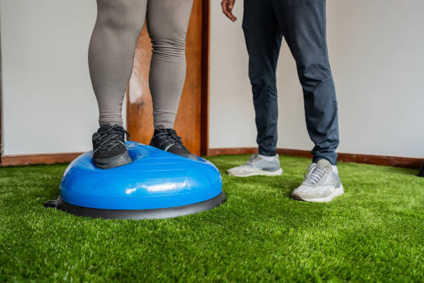 Fitness instructor helping student practice proprioception exercise in a health club