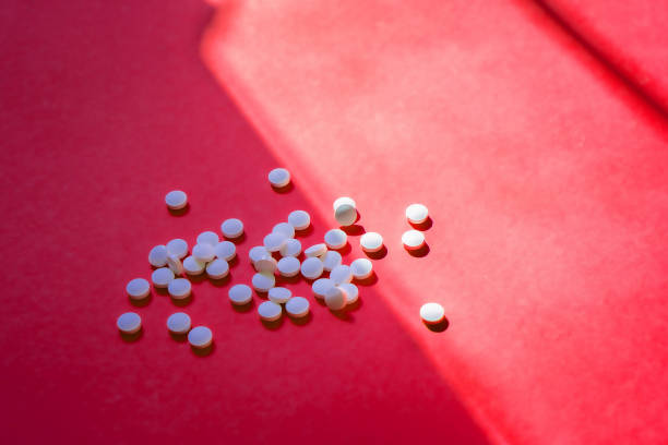 istock Assorted pharmaceutical medicine pills, tablets and capsules and bottle on red background. Copy space for text 2194895072