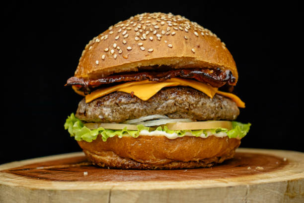 istock Delicious gourmet handmade burger with cheddar, special white sauce, crispy bacon, lettuce, tomato, onion and sesame seed bun. 2194895722