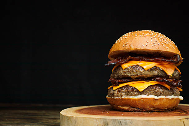 Delicious gourmet double handmade burger with double cheddar, special white sauce, crispy bacon and sesame seed bun.