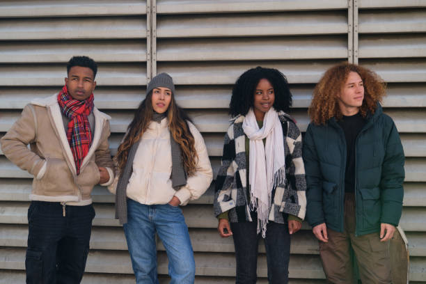 istock Young students standing against a wall in winter clothes 2194896977