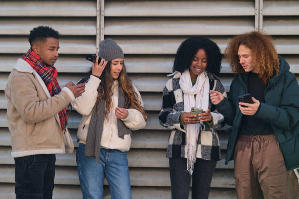 istock Young people using smartphones and having fun together outdoors 2194897528